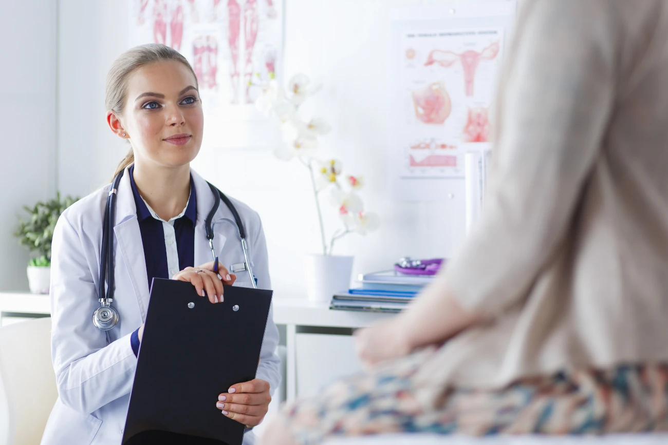 Ärztin im Gespräch mit Patientin in moderner Praxis, Beratung zur Frauengesundheit.